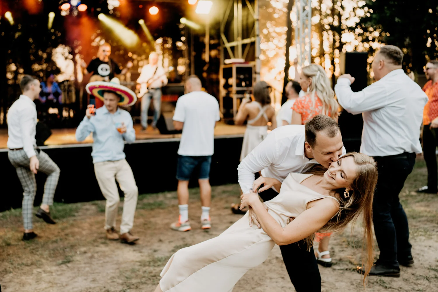 Vyras bučiuoja merginą per vestuves, vestuvių fotografas